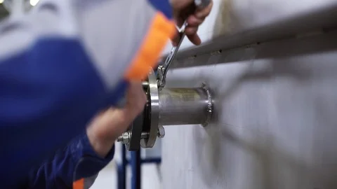 The engineer screws the bolts onto the flange connection. Stock Footage 93207708