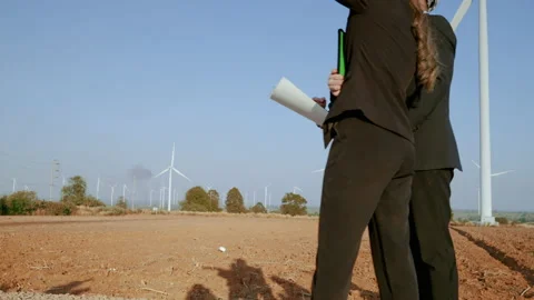 Engineer with a secretary are inspecting a project in a wind turbine field Stock Footage 169308915