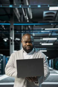 Engineer in server farm managing infrastructure systems, checking recovery plan Stock Photos