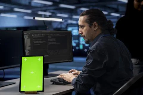 Engineer in server hub using chroma key PC to repair equipment storing datasets Foto stock