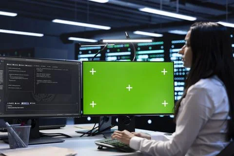 Engineer in server hub using green screen PC to repair equipment storing Foto stock