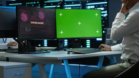 Engineer in server hub using green screen PC to stop hacker Stock Photos
