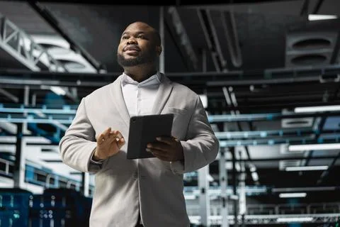 Engineer in server room overseeing mainframes gear 스톡 사진