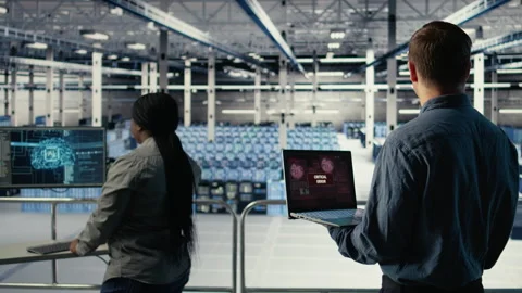 Engineer in server room receives critical error popup on laptop screen 库存影片 314803436