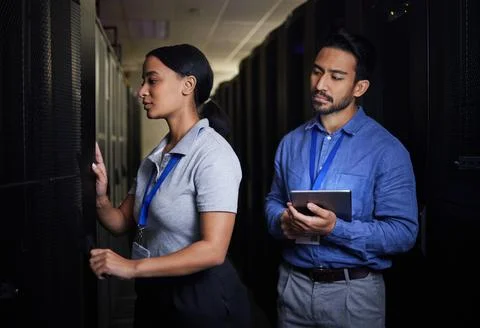Engineer, server room teamwork and woman opening panel for maintenance or Stock Photos