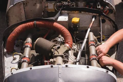 Engineer servicing aircraft engine near hangar 写真素材