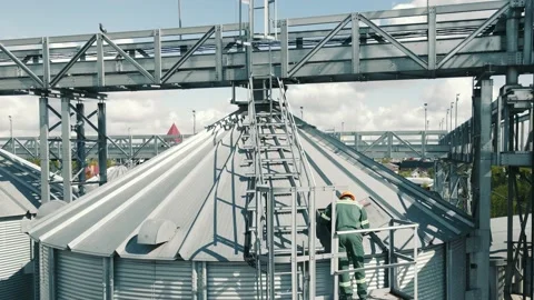 Engineer servicing and inspecting large grain storage containers. An employee of Stock Footage 158546350