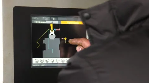 The engineer sets the program for the CNC machine. Stock Footage 101777054