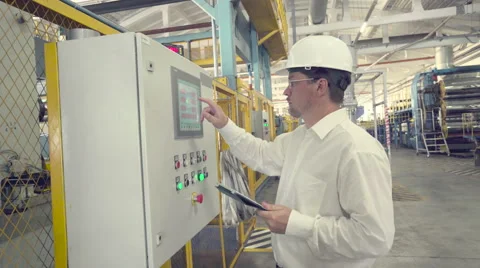 Engineer is setting up CNC machine Stock Footage 65457644