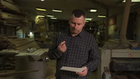 Engineer in shirt stands against background of production with sketch on paper Stock Footage 149313295