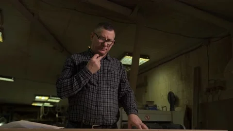 Engineer in shirt stands against background of production with sketch on paper Stock Footage 149313485