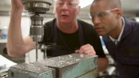 Engineer Showing Apprentice How To Operate Drilling Machine Video stock 40430149