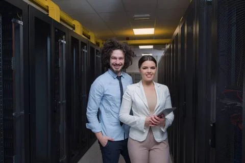 Engineer showing working data center server room to female chief Young IT ... Stock Photos