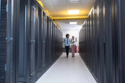 Engineer showing working data center server room to female chief Young IT ... Foto stock