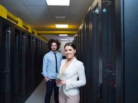 Engineer showing working data center server room to female chief Young IT ... Foto stock