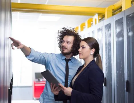 Engineer showing working data center server room to female chief Young IT ... Foto stock