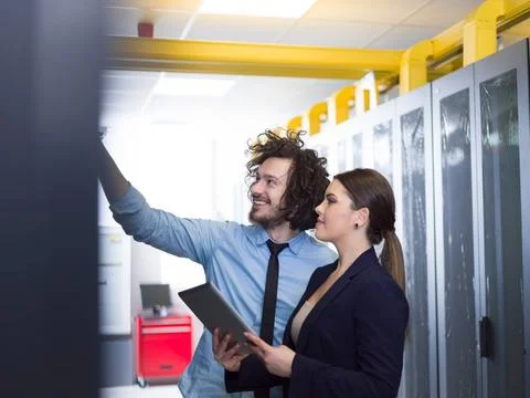 Engineer showing working data center server room to female chief Young IT ... Foto stock