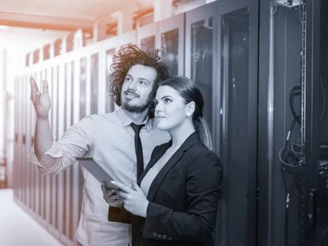 Engineer showing working data center server room to female chief Young IT ... Foto stock