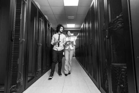 Engineer showing working data center server room to female chief Young IT ... Foto stock