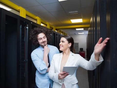 Engineer showing working data center server room to female chief Young IT ... Stock Photos
