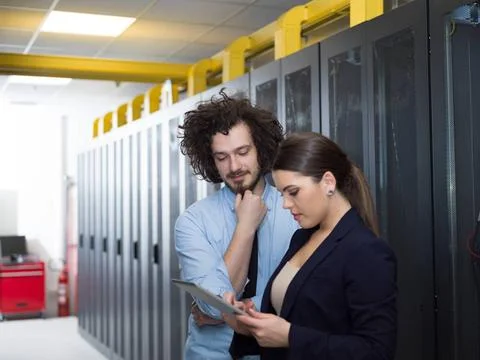 Engineer showing working data center server room to female chief Young IT ... Foto stock
