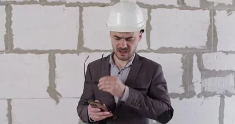 Engineer shows frustration with information on smartphone Stock Footage 309929460