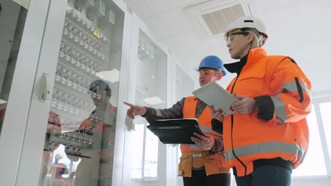 Engineer shows new switchboard cabinets to female inspectors Stock Footage 144099915