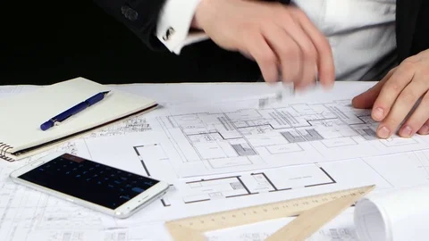 Engineer sits at the table and checks the correctness of the drawing. Close up Vidéo 73679565