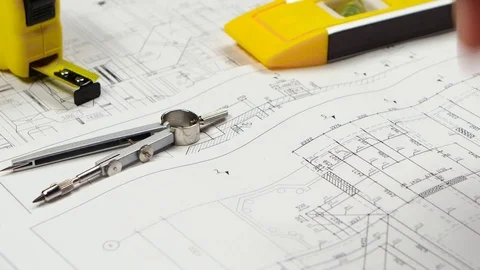 Engineer sits at the table, chooses a drawing that is more optimal for him Stock Footage 73674274