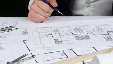 Engineer sits at the table examines the drawing of the new store. Close up Stock Footage 73679903