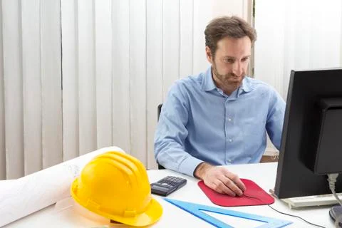 Engineer sitting in front of the computer in his office Stock Photos