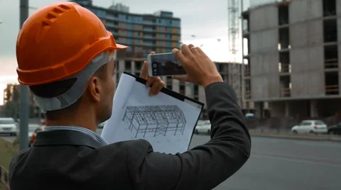 Engineer with the smart phone taking pictures of construction Stock Footage