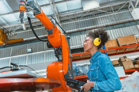 Engineer smart woman worker working programing robotic welding machine. Black Foto stock