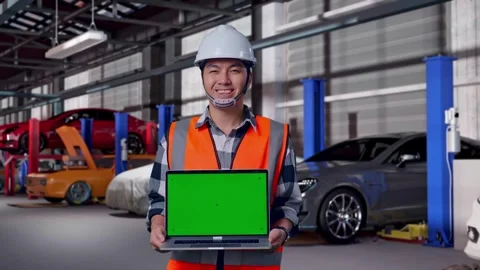 Engineer Smiling And Showing Green Screen Laptop in Auto Repair Shop Stock Footage 313531433