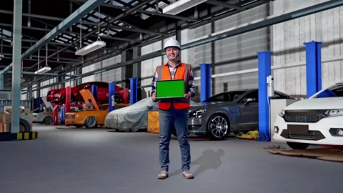 Engineer Smiling And Showing Green Screen Laptop in Auto Repair Shop Stock Footage 313533851