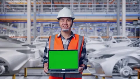 Engineer Smiling And Showing Green Screen Laptop In Car Factory Stock Footage 331576805