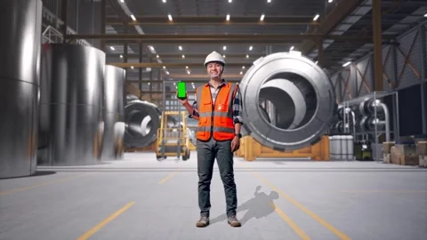 Engineer Smiling And Showing Green Screen Smartphone at Heavy Factory Stock Footage 340821415