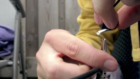 Engineer soldering a blue wire to a switch outdoor with a soldering iron. Stock Footage 146310160