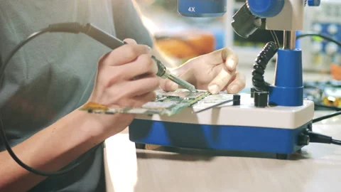 Engineer is soldering a microcircuit under a microscope Stock Footage 145539519