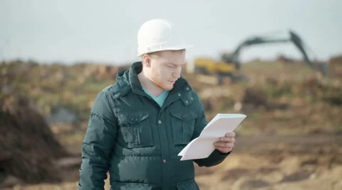 Engineer Speak on Phone, Looking Documents and Calls Worker on Background of Stock Footage 62417905