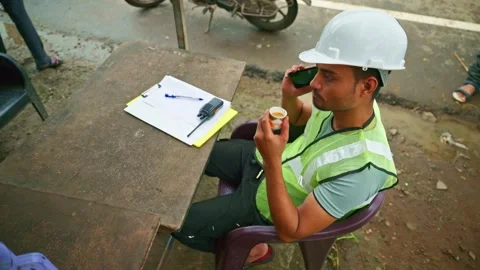 Engineer speaks by mobile while having coffee Stock Footage 297601077