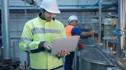 Engineer specialist checking and controlling machine in industrial factory Stock Photos