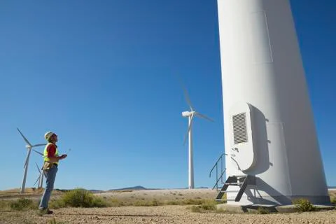 Engineer standing on field against clear blue sky Stock Photos