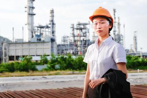 The engineer is standing on large industry background. Stock Photos