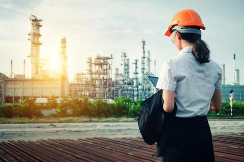 The engineer is standing on large industry background. Stock Photos