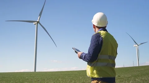 Engineer standing near wind mill and checking information on dev Stock Footage 111066908