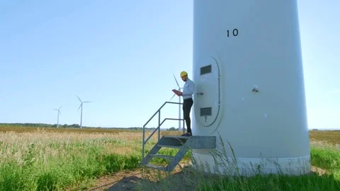 The engineer is standing on the steps of a windmill. Video stock 76582220