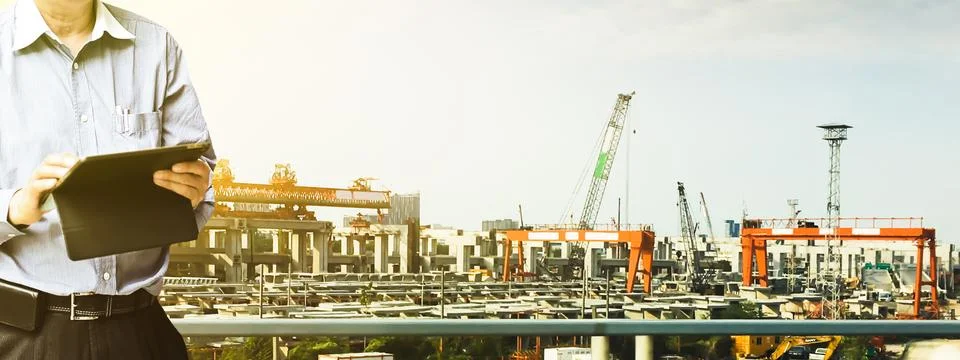 Engineer standing using tablet control and manage work at construction site. Stock Photos