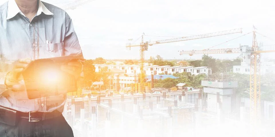 Engineer standing using tablet control and manage work at construction site. Stock Photos