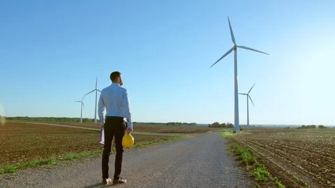 The engineer stands and looks at the windmills. 動画素材 76594117